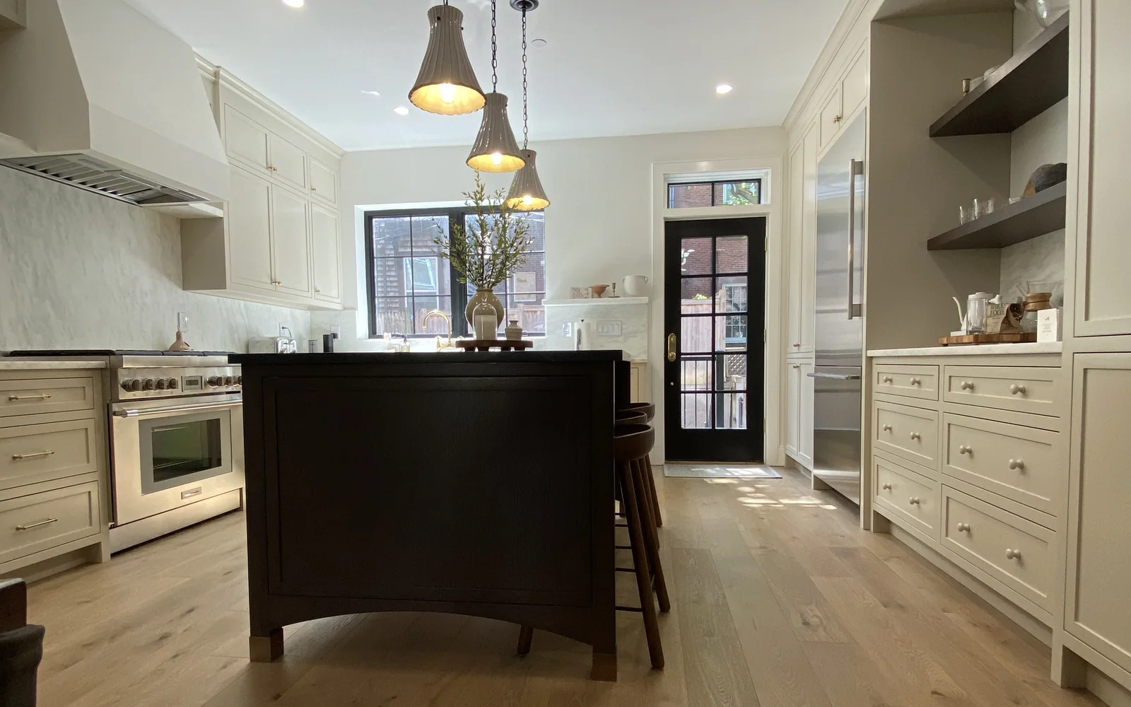 Completed Kitchen Island Remodel with a dark center island and custom white cabinetry